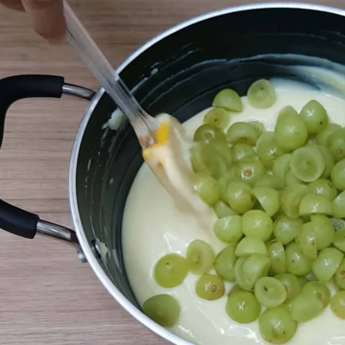 Colocando uvas picadas junto com o creme branco