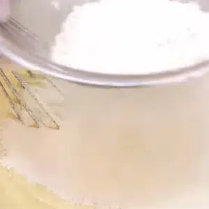 peneirando a farinha para preparar o bolo de banana