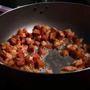 calabresa e bacon fritando