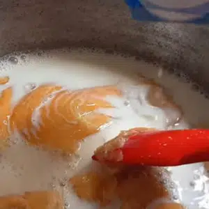 adicionando leite no caramelo para fazer ambrosia