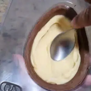 colocando o recheio dentro do ovo de chocolate