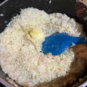 adicionando a manteiga e o queijo no risoto de camarao