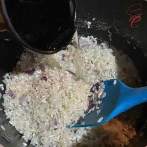 adicionando o arroz e um pouco de caldo na panela