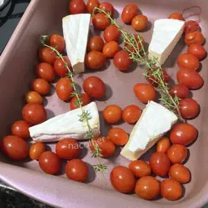 colocando dentro de uma travessa o queijo os tomates e o alecrim