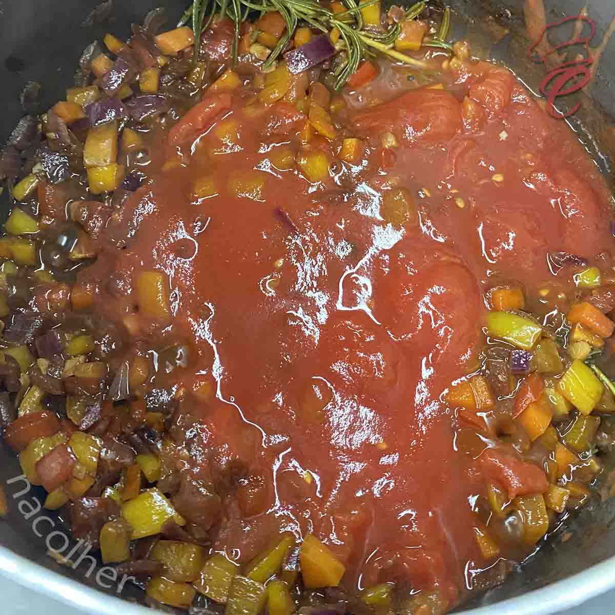 acrescentando o molho de tomate no refogado para preparar a carne do buraco quente