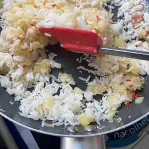 juntando o arroz pronto com o abacaxi refogado com a pimenta