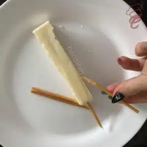 quebrando o palito do queijo coalho para diminuir