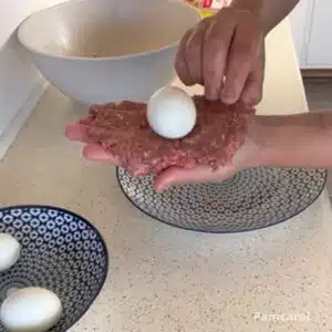 abrindo a carne para colocar o ovo do bolovo dentro
