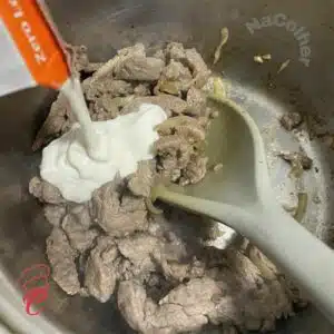 adicionando creme de leite no filé para strogonoff