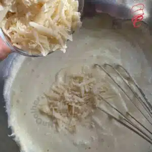 colocando o queijo ralado na clara em neve no suflê