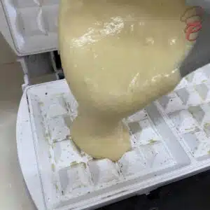 colocando a massa de waffle na maquina