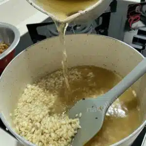 colocando caldo no risoto