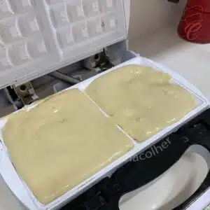 espalhando a massa de waffle na maquina