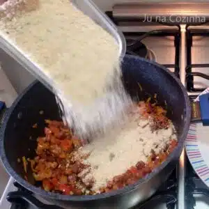 adicionando farinha de mandioca na farofa de churrasco