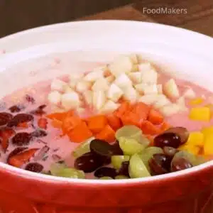colocando as frutas na salada de frutas com gelatina