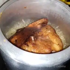 virando frango assado na panela de pressão