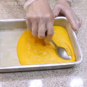 espalhando a massa do bolo de cenoura recheado na forma
