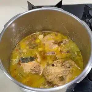 abrindo a panela de pressao depois de cozinhar o frango para preparar o caldo