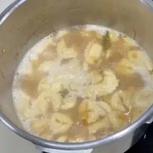 cozinhando o capeletti no caldo